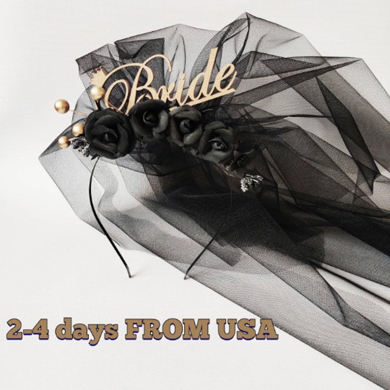 May include: Black bridal veil with a wooden "Bride" inscription, a small gold crown, and black rose accents. The veil is made of sheer black fabric and features gold-colored beads.