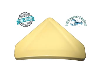 May include: A yellow corner shelf made of ceramic. The shelf is triangular in shape and has a rounded edge.