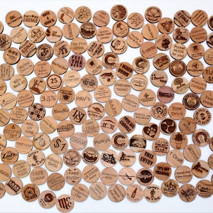 Puede incluir: Una colecci&oacute;n de fichas redondas de madera con varios dise&ntilde;os y textos, incluyendo nombres de negocios, descuentos y promociones. Las fichas est&aacute;n dispuestas en un patr&oacute;n circular sobre un fondo blanco.