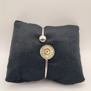Op de afbeelding: Een zilverkleurige metalen armband met een gepolijst bolvormig uiteinde en een rond middendeel gemaakt van een messingkleurige Hornady 30-08 patroonhuls met zichtbare tekstmarkeringen rondom het centrale slaghoedje.