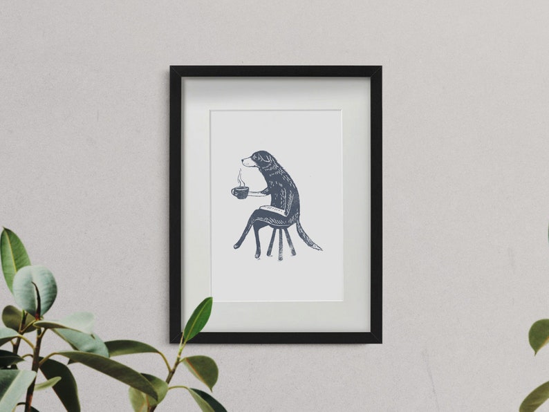 Puede incluir: Una ilustraci&oacute;n en blanco y negro de un perro sentado en una silla y sosteniendo una taza de caf&eacute;. El perro tiene una expresi&oacute;n humana y mira hacia la derecha. La ilustraci&oacute;n est&aacute; enmarcada en un marco negro.