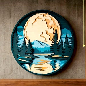 Peut inclure: Une décoration murale circulaire en bois multicouche représentant une grande lune crème, des sapins bleu sarcelle foncé et un lac bleu réfléchissant. Le texte DXF, AI, SVG et DIGITAL CUTTING FILE indique un fichier de découpe numérique.