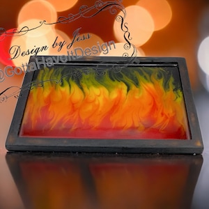 May include: A black framed tray with a resin art design of flames in shades of red, orange, yellow, and green. The text "Design by Jess @GottaHaveItDesign" is visible in the top left corner of the image.