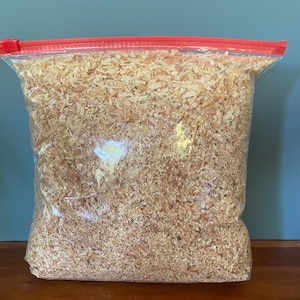 May include: A clear plastic bag with a red zipper closure filled with wood shavings.