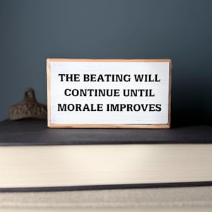 Funny Office Desk Wood Sign – The Beating Will Continue