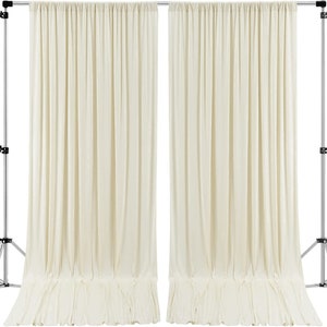 May include: Two ivory white fabric backdrops hanging from a silver stand. The backdrops are wrinkle-free and have a slight sheen.