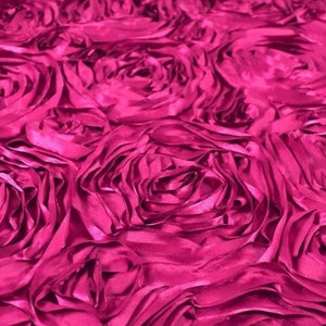 May include: A close-up of a fuchsia pink fabric with a ruffled rose pattern. The fabric is soft and luxurious, perfect for adding a touch of elegance to any project.