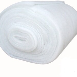 May include: A white, rolled up piece of batting, a type of fiberfill used for quilting and crafts.
