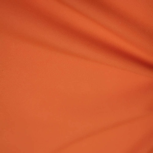 May include: A close-up of a smooth, orange fabric with a subtle texture. The fabric is folded and has a soft, warm appearance.