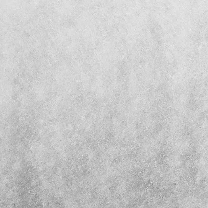 May include: A close-up of a white, textured surface. The surface has a subtle, grainy appearance, resembling a fine-grained fabric.