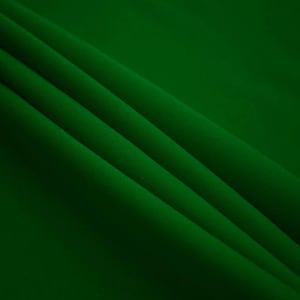 May include: A close-up of a smooth, dark green fabric with soft folds. The fabric has a subtle sheen and a luxurious feel.