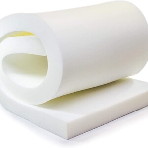 May include: A white foam mattress topper rolled up and ready to be unrolled. The topper is about 2 inches thick and is made of high-density foam.