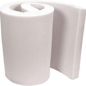 May include: A white foam roll, rolled up and partially unrolled, showing the thickness of the foam. The foam is a light white color and has a smooth texture.