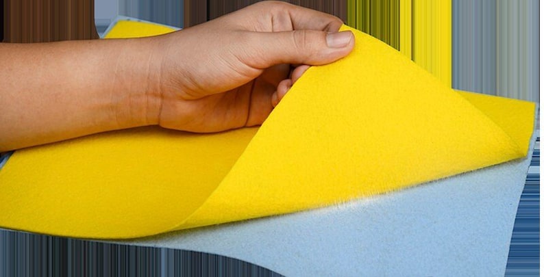 Puede incluir: Una hoja de fieltro amarillo se est&aacute; despegando para revelar una hoja de fieltro azul claro debajo.