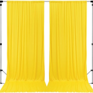 May include: Two bright yellow fabric backdrops hanging from a silver stand. The backdrops are wrinkle-free and smooth.