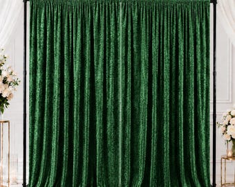May include: A dark green crushed velvet backdrop curtain suspended on a black metal adjustable stand. The fabric features a textured, light-reflecting surface with vertical folds, creating a full, draped appearance across the frame.