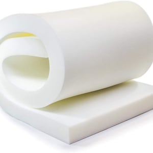 May include: A white foam mattress topper rolled up and ready to be unrolled. The topper is about 2 inches thick and is made of high-density foam.