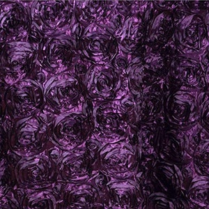 May include: Purple fabric with a 3D rose pattern. The fabric is made of a soft, silky material and has a subtle sheen.
