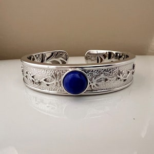 VM KN 925 Sterling silver 925 blue gemstone hinged  cuff with a round center blue stone and a beautiful design along the band.