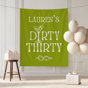 May include: A green banner with the text "LAUREN'S DIRTY THIRTY" in white, along with a martini glass illustration and olive skewers. White balloons and gift boxes with pink bows are also present, suggesting a birthday celebration.