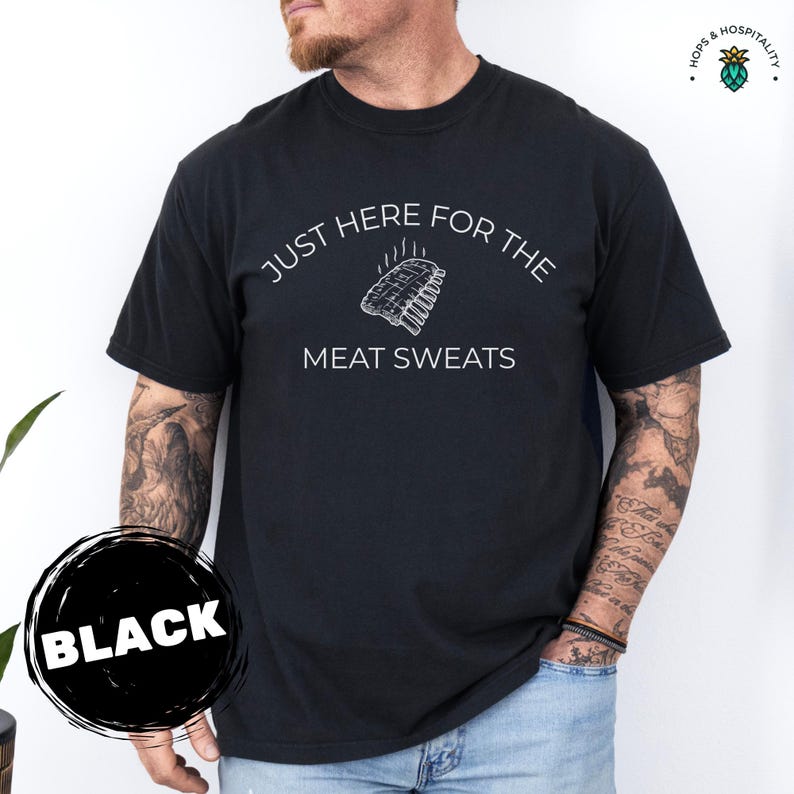 K&ouml;nnte beinhalten: Schwarzes T-Shirt mit dem wei&szlig;en Text "JUST HERE FOR THE MEAT SWEATS" und einer Rippchen-Grafik. Ein "BLACK"-Etikett befindet sich in einem schwarzen Kreis. Ein l&auml;ssiges Kleidungsst&uuml;ck.