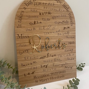 May include: A wooden archway sign with the text "It takes a big heart to shape little minds" and the names of children in a classroom. The sign also includes the text "Miss Roberts" and "Reception 2022/2023 St Mary's Horsforth".