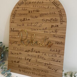 May include: A wooden plaque with a rounded top, featuring the text "It takes a big heart to shape little minds."  The plaque is inscribed with the names of children, including "Roberts", and the text "Reception 2022/2023 St Mary's Horsforth".