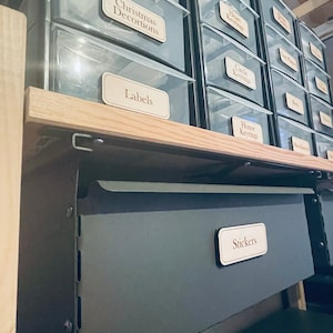 Może przedstawiać: Zestaw przezroczystych plastikowych pojemników do przechowywania z drewnianymi etykietami. Etykiety są do ozdób choinkowych, breloków w kształcie serca, okrągłych breloków, breloków do domu, etykiet i naklejek.