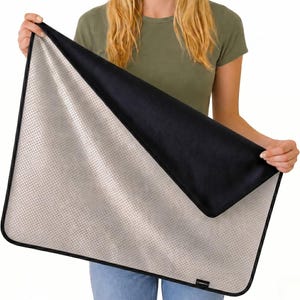 May include: A rectangular mat featuring a light beige surface with a fine dark grid pattern and a solid black underside. The mat is finished with a black fabric border and includes a small black rectangular tag with white text on the bottom edge.