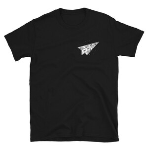 May include: Black short-sleeved t-shirt with a white paper airplane graphic. The airplane is filled with a detailed design.