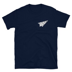 May include: A navy blue t-shirt with a white paper airplane graphic. The airplane is folded and has a detailed design.