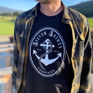 May include: Black t-shirt with a white circle logo featuring an anchor and the text "Silver Saints Company Est. 2018".