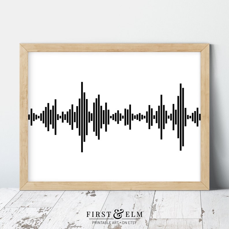 Pu&ograve; includere: Stampa grafica di un'onda sonora astratta in bianco e nero in una cornice di legno chiaro. La stampa &egrave; un design semplice di linee verticali di altezze variabili.