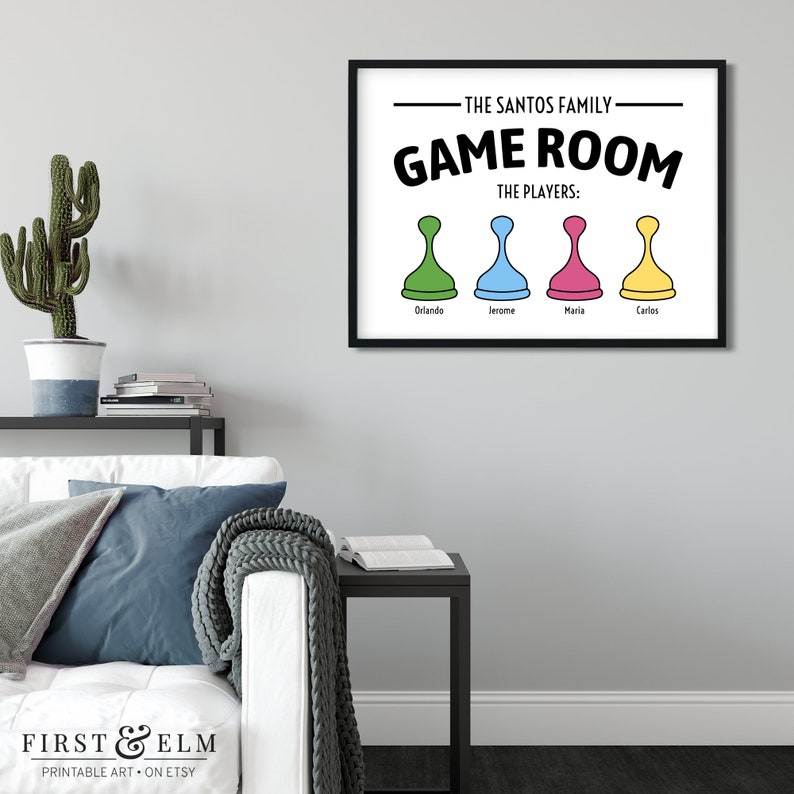 May include: A printable wall art design for a games room. The design features the text "The Santos Family - Game Room" with the text "The Players:" below. Four game pieces are shown with the names Orlando, Jerome, Maria, and Carlos below each piece.