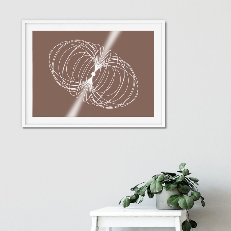 May include: A framed print featuring a white abstract design on a brown background. The design consists of overlapping circles.