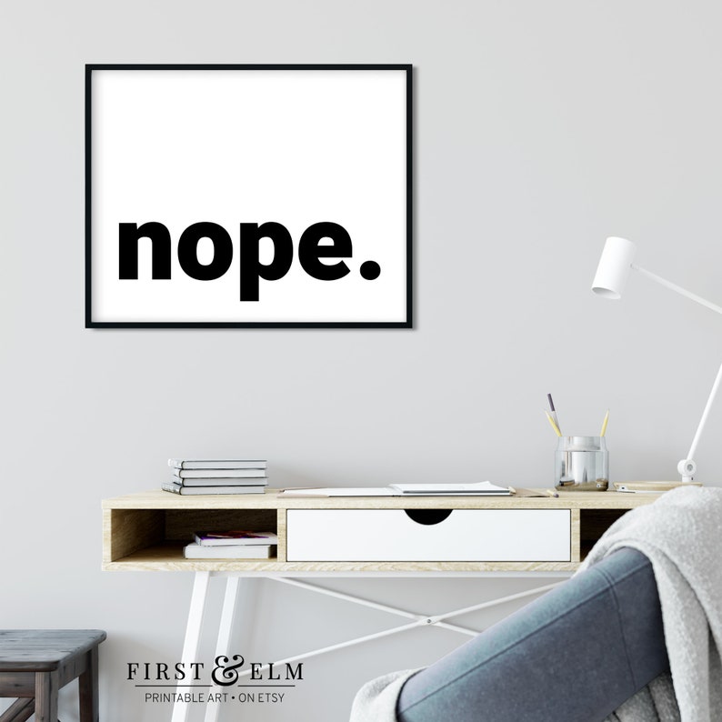 May include: A black and white printable art print with the word "nope" in bold, black letters. The print is framed in a black frame and is hanging on a white wall.