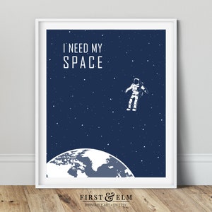 May include: A blue and white printable art print featuring an astronaut floating in space above the Earth. The text "I need my space" is at the top of the print.