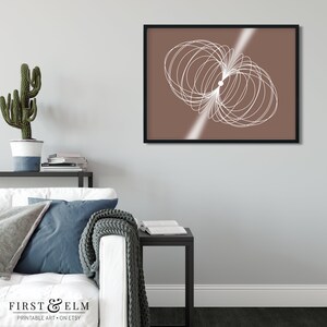 May include: A digital art print featuring a white abstract design on a brown background. The design is a series of overlapping circles and lines, creating a sense of movement and energy. The print is framed in a black frame.
