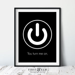May include: A black and white printable art print with a white power button symbol in a circle and the text "You turn me on." The print is framed in a black frame.