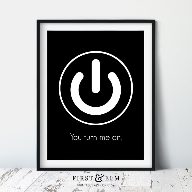 May include: A black and white printable art print with a white power button symbol in a circle and the text "You turn me on." The print is framed in a black frame.