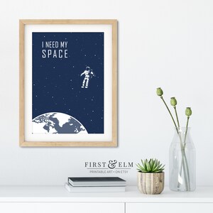 May include: A blue and white printable art print featuring an astronaut floating in space above the Earth. The text "I need my space" is at the top of the print.
