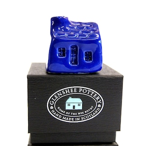 May include: A cobalt blue ceramic house figurine with a textured roof and windows, presented on a black gift box. The box features a white oval logo with the text "Glenshee Pottery, Home of the Wee Bothy, Hand Made in Scotland."