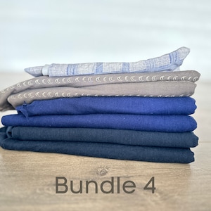 May include: A stack of six fabric squares in various shades of blue and gray. The top square has a light blue and white pattern. The second square has a gray background with a white crescent moon pattern. The bottom four squares are various shades of blue. The text "Bundle 4" is written below the stack of fabric.