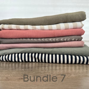 May include: A stack of seven fabric swatches in various colors and patterns, including striped, solid, and patterned. The swatches are folded neatly and labeled "Bundle 7".