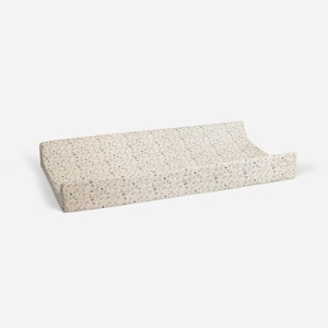 May include: A cream-colored changing pad with a floral pattern in shades of gray. The pad is made of a soft, comfortable material and is perfect for changing babies.