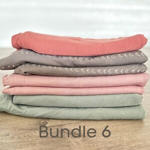 May include: A stack of six fabric squares in various shades of pink, green, and brown. The fabric squares have a subtle pattern of white crescent moons. The text "Bundle 6" is printed below the stack of fabric.