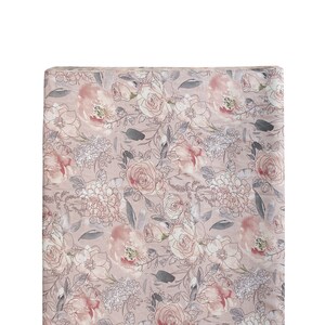 Op de afbeelding: Een roze en witte bloemenstof met een aquarelontwerp. De stof heeft een verscheidenheid aan bloemen, waaronder rozen, lelies en hortensia's.