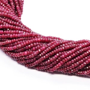 Puede incluir: Una hebra de cuentas de piedras preciosas facetadas de color rojo rubí. Las cuentas son pequeñas y redondas, y están enhebradas en un hilo transparente.