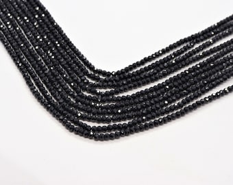 May include: A strand of black faceted beads, arranged in a fan shape. The beads are small and uniform in size.