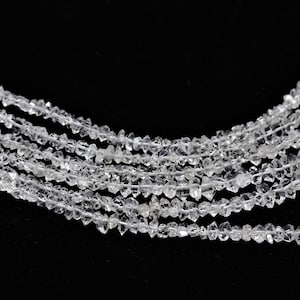 K&ouml;nnte beinhalten: Eine Str&auml;hne aus klaren, facettierten, diamantf&ouml;rmigen Perlen. Die Perlen sind auf einem durchsichtigen Faden aufgereiht und in einer Reihe angeordnet. Die Perlen sind alle gleich gro&szlig; und gleich geformt.
